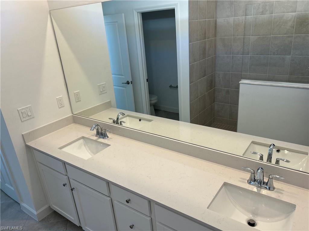 Double vanity with two integrated sinks, chrome faucets, and white shaker-style cabinetry