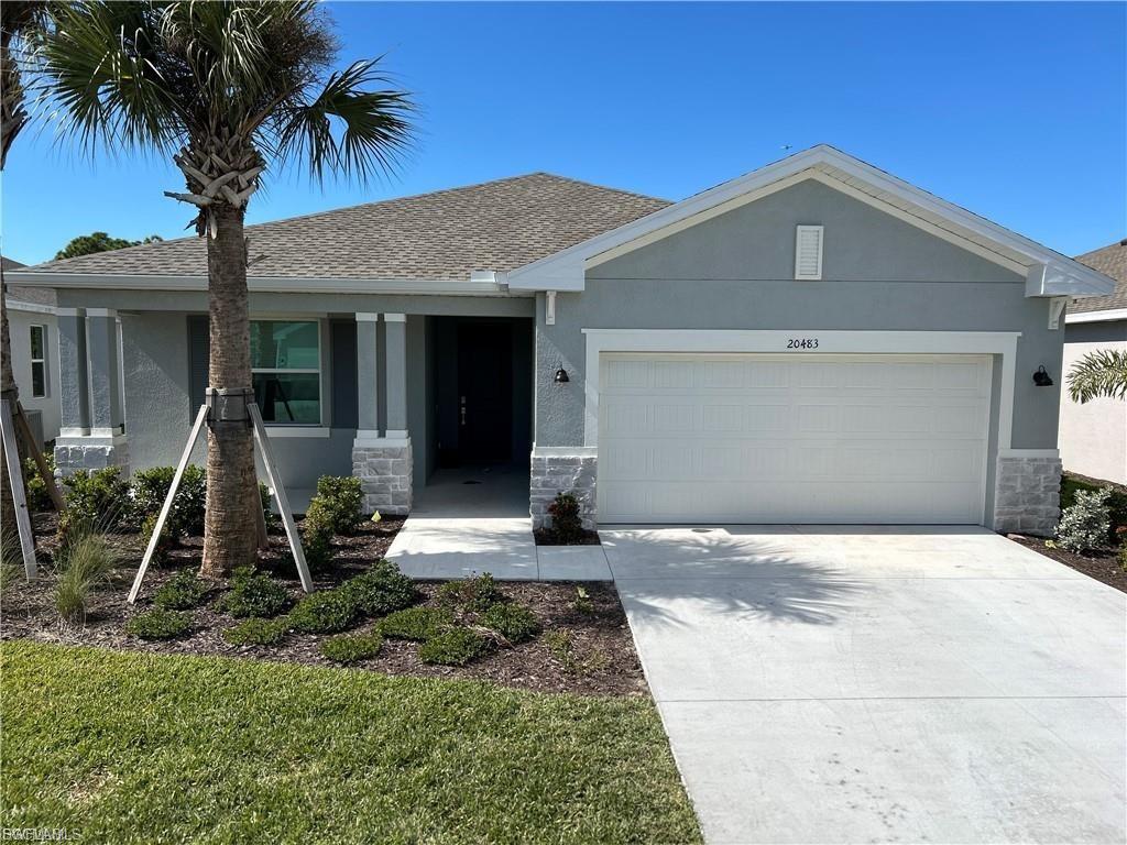 Contemporary single-story residence with a light gray stucco exterior and a gray shingle roof