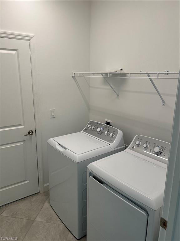 Dedicated laundry space featuring a white top-load washing machine, a white front-load dryer, and an overhead wire shelf