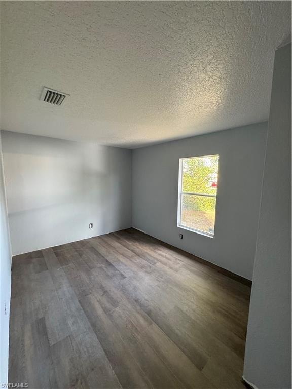 Room featuring wood-finish flooring, light gray wall paint, and a window providing natural illumination