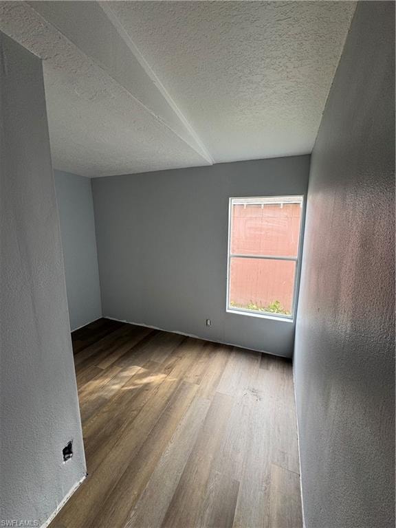 Room featuring wood-finish flooring, light gray painted walls, and a single window