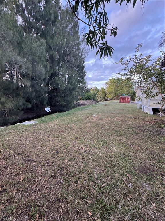 Expansive grassy area with mature trees and a visible water canal