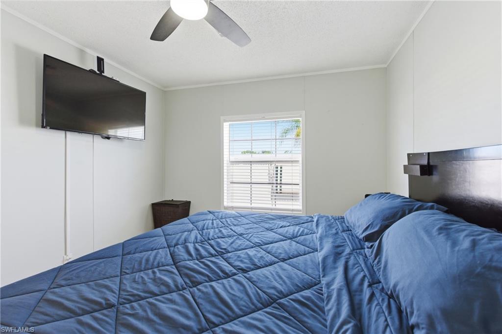 Room featuring a window with horizontal blinds, a ceiling fan, and light-toned walls