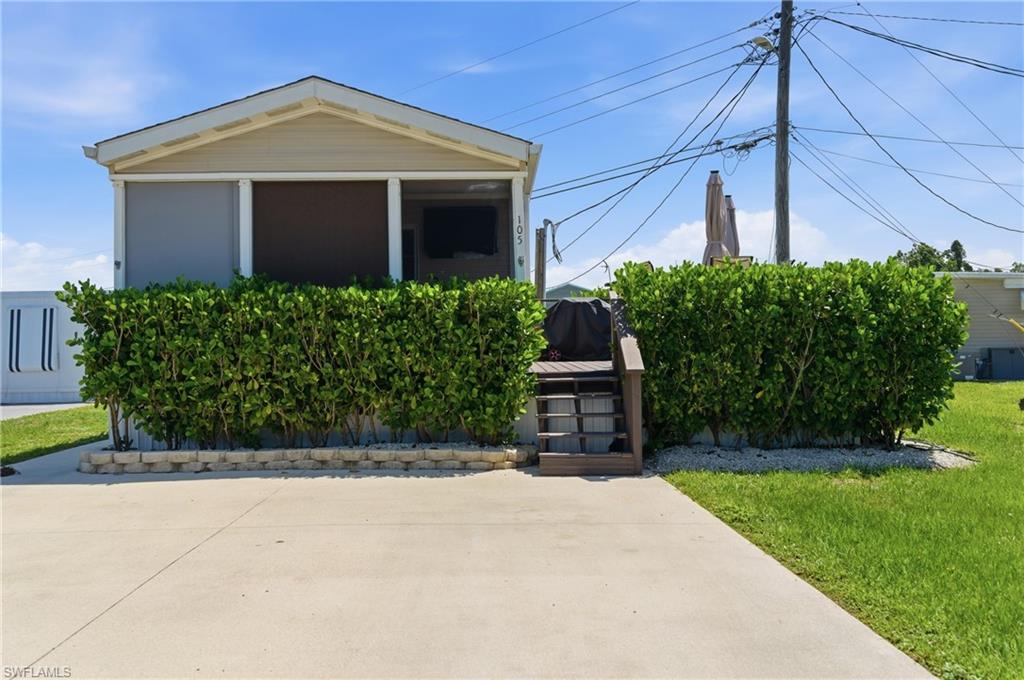 Front of property with paved driveway and steps to Deck