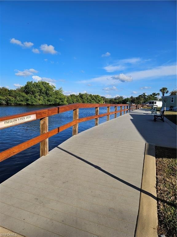 Concrete pier featuring a wood-finish railing and a built-in bench