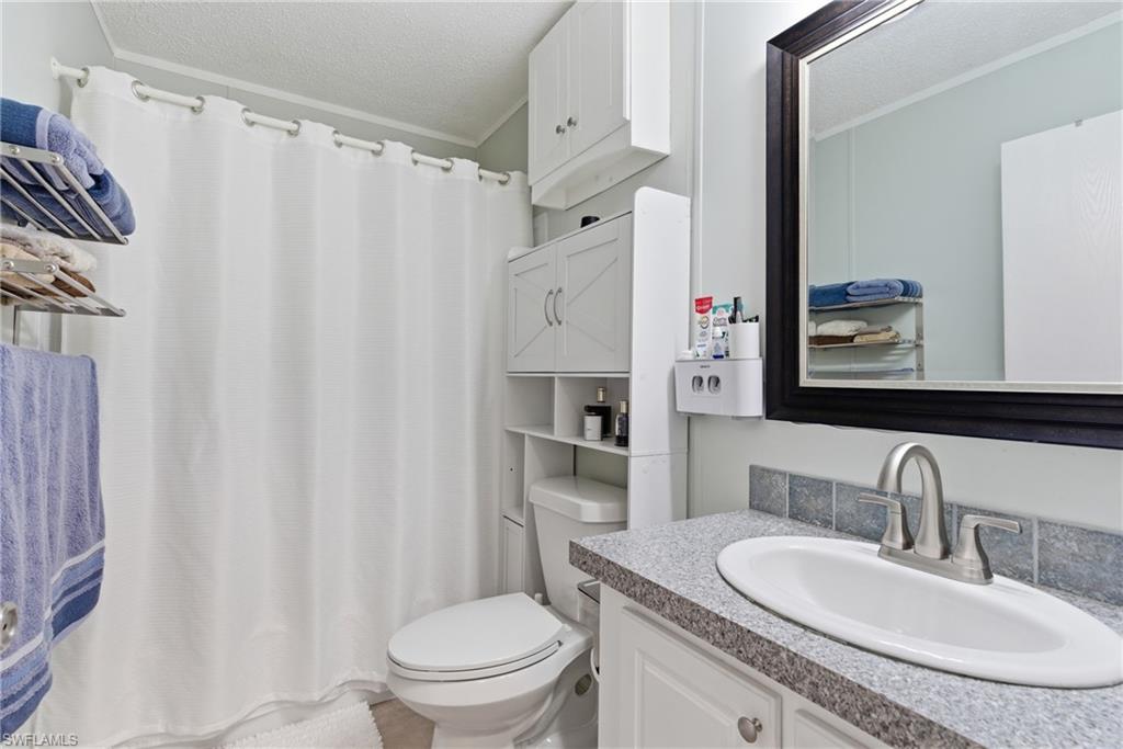 Bathroom featuring a vanity with an integrated sink, speckled countertop, and tiled backsplash