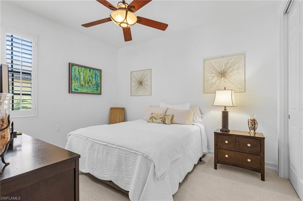 Bedroom featuring light colored carpet, a closet, and a ceiling fan