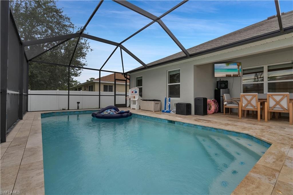 View of pool featuring a sunroom, a patio area, and a lanai