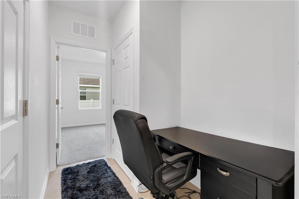 Home office featuring light carpet and light tile patterned floors
