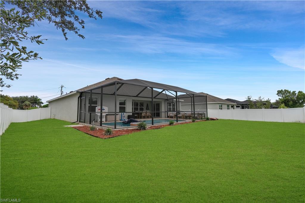 Back of property featuring a sunroom, a fenced backyard, glass enclosure, and a patio area