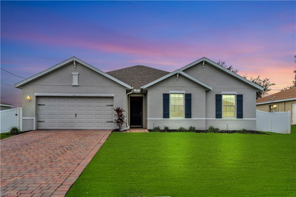 Ranch-style home featuring stucco siding, decorative driveway, an attached garage, and a shingled roof