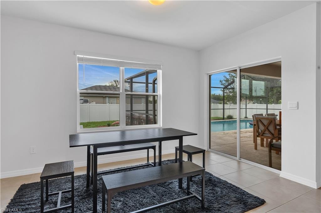 Dining room with light tile patterned floors and a sunroom