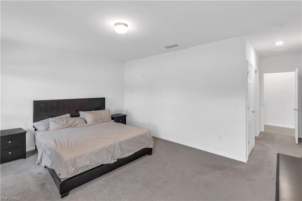 Bedroom featuring carpet and baseboards