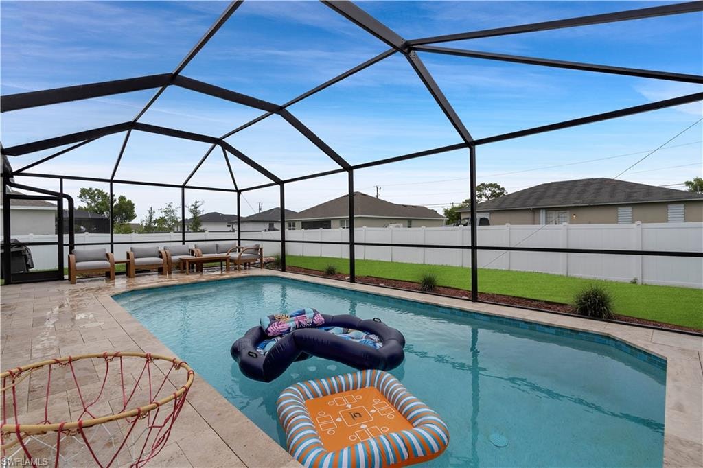 View of swimming pool featuring a lawn, a lanai, and a sunroom