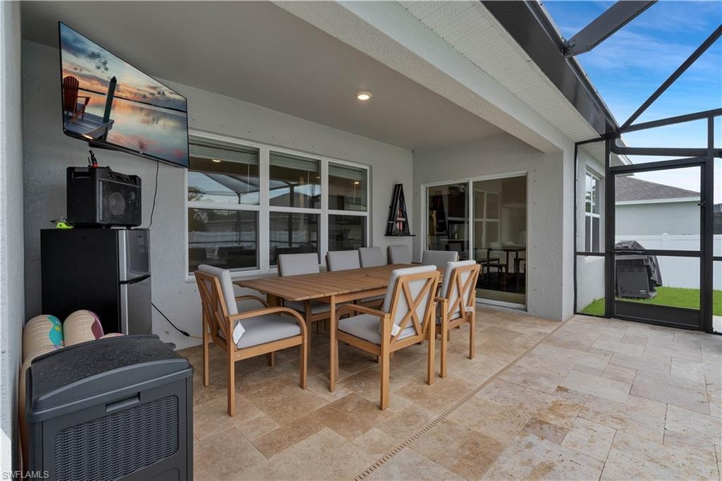 Sunroom with outdoor dining area and a patio