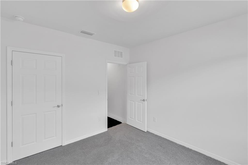 Unfurnished bedroom with carpet floors and baseboards