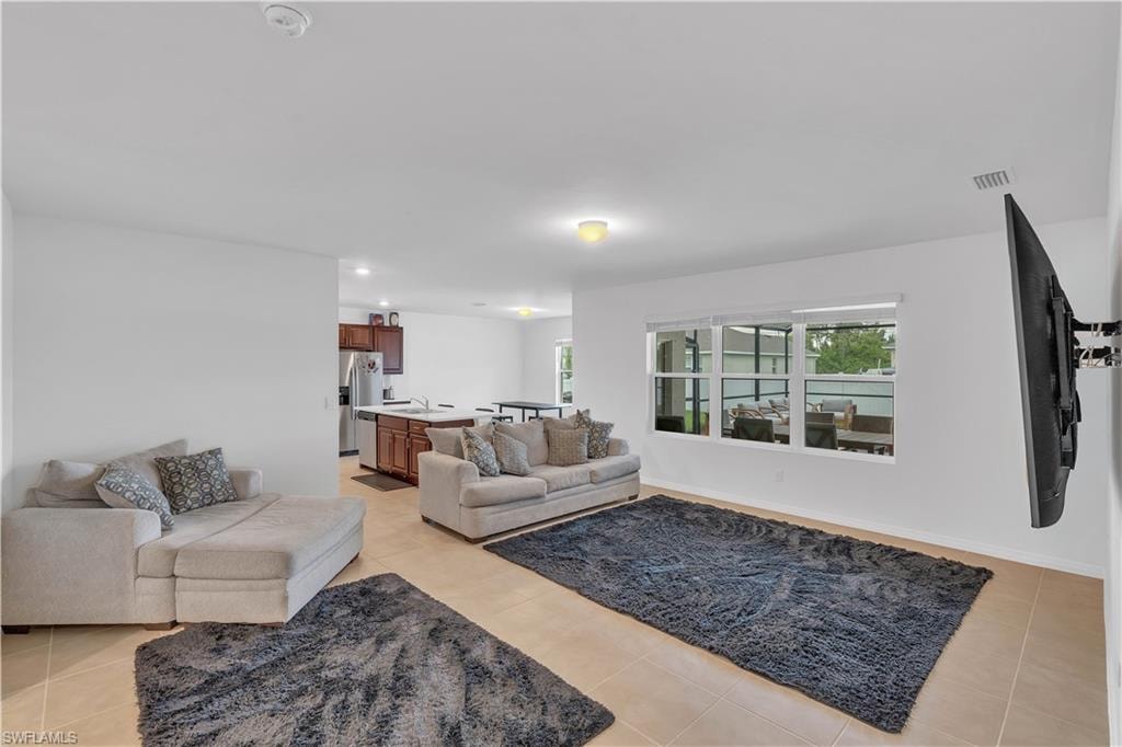 Living room with light tile patterned flooring and recessed lighting