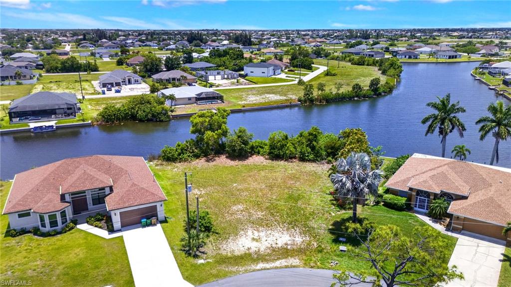 Expansive vacant lot featuring a cleared building envelope, waterfront access, and surrounding residential properties
