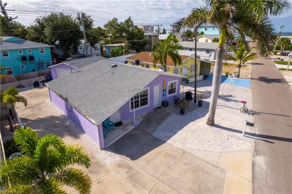 Purple exterior with white trim, featuring a shingle roof and a concrete driveway