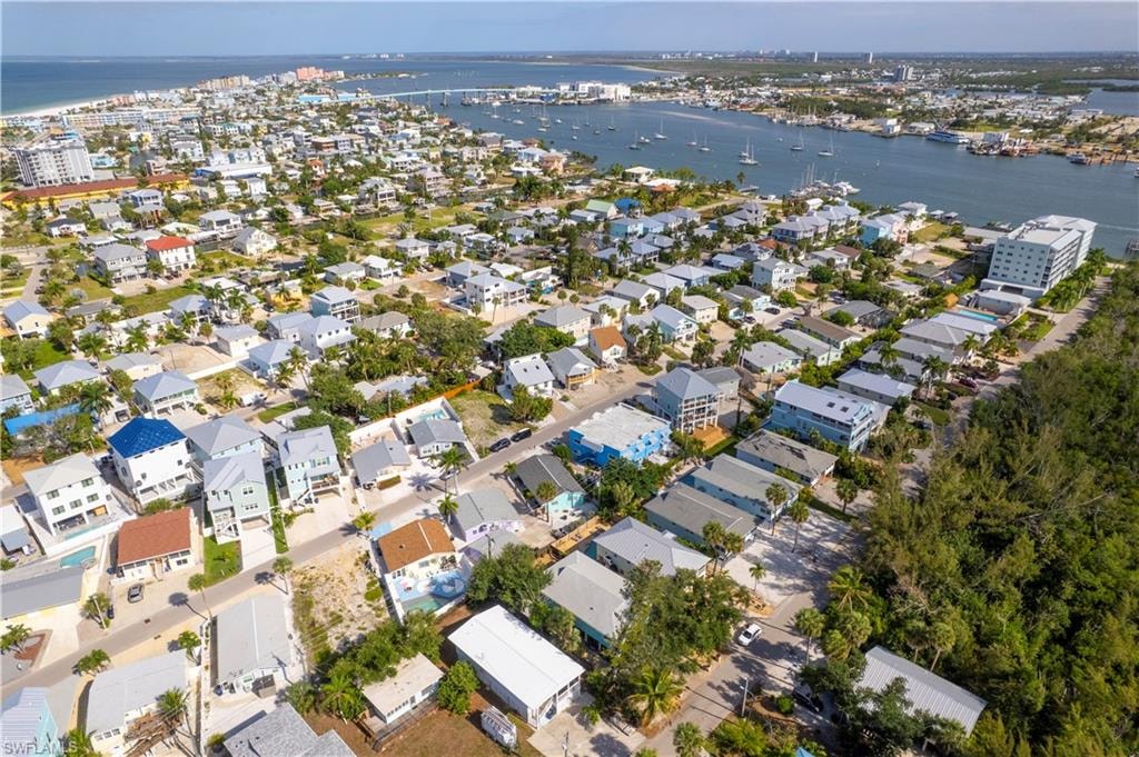 Aerial perspective of a coastal community with numerous residential properties, canals, and a distant body of water