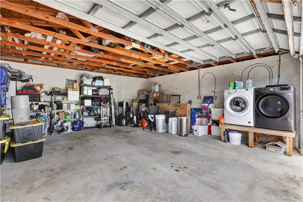 Attached garage with exposed wood ceiling joists and concrete flooring