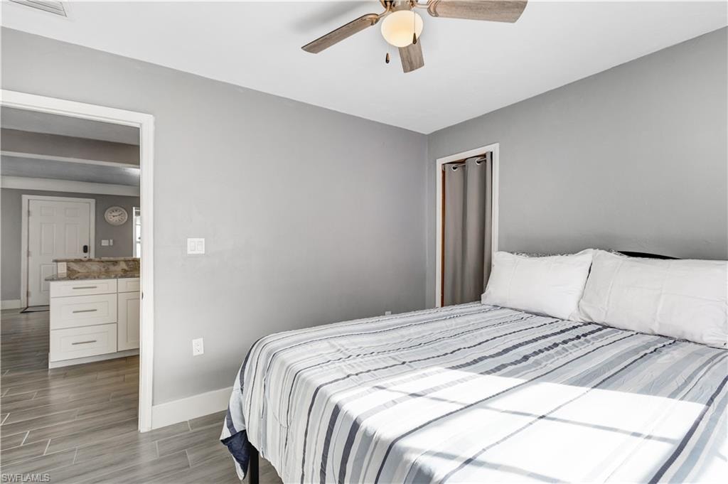 Room featuring light gray walls, wood-finish flooring, and a ceiling fan with integrated lighting