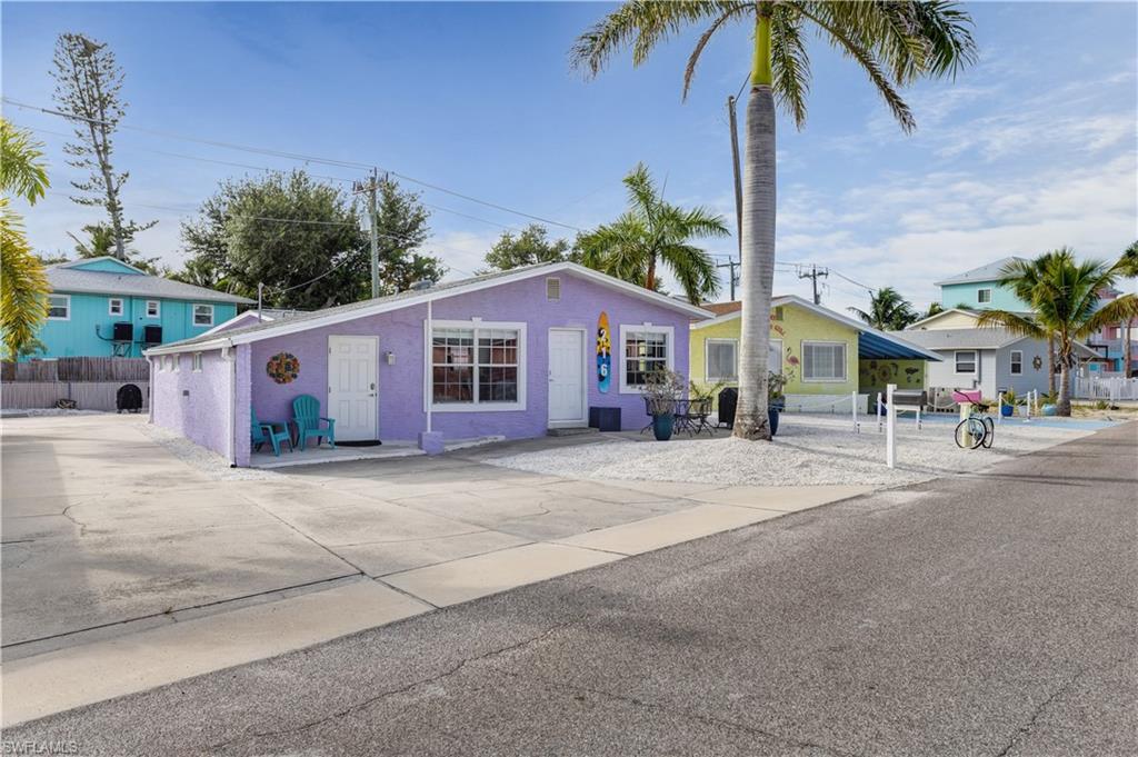 Purple exterior with white trim, featuring a concrete driveway and an additional side entrance