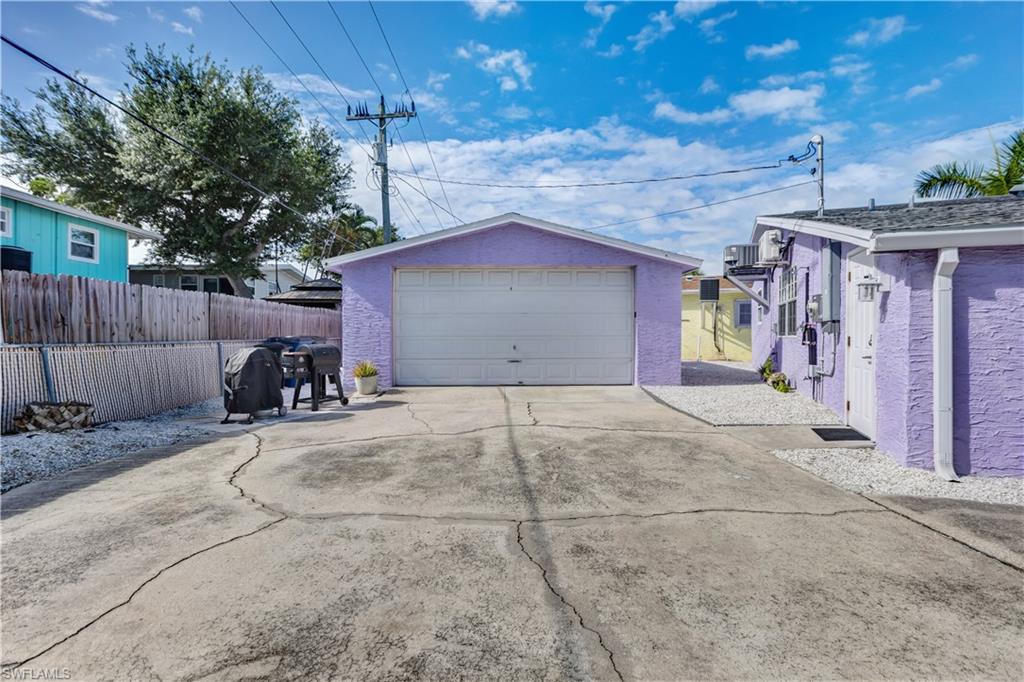 Purple stucco exterior with white trim and a single garage door