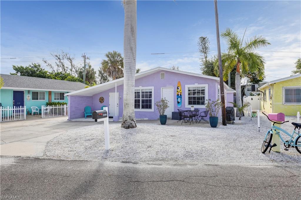 Lavender exterior with white trim, featuring a covered carport and a gravel-covered front yard