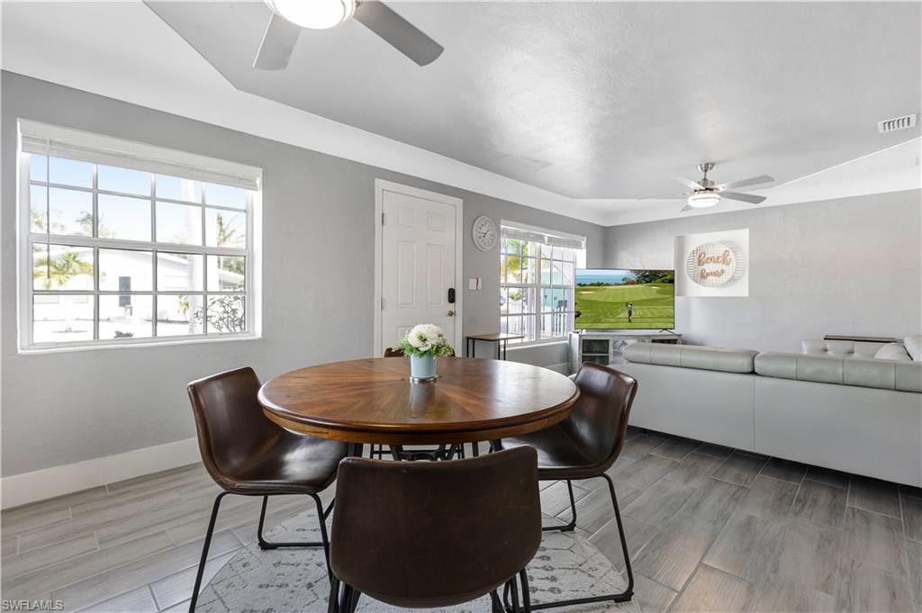 Open-concept living space with wood-finish tile flooring and recessed lighting