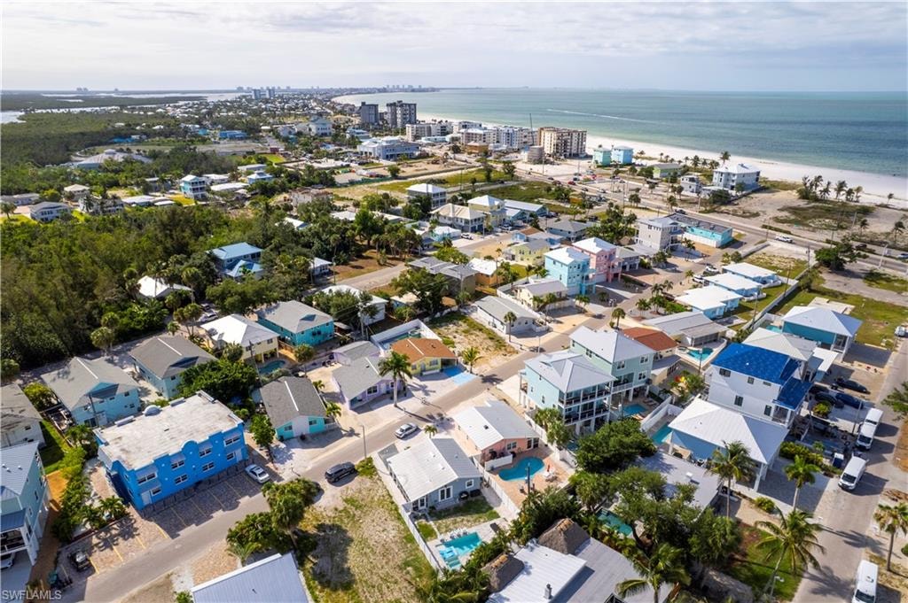 Coastal community featuring diverse architectural styles, proximity to a white sand beach, and clear ocean waters