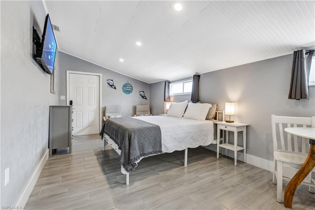 Spacious room with light gray walls and wood-finish flooring