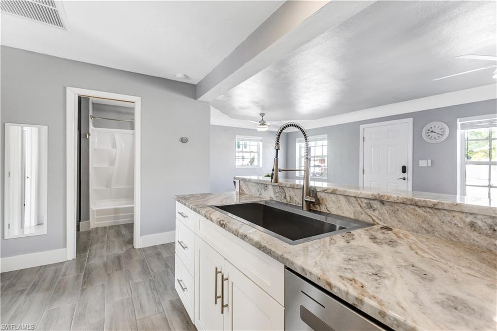 Kitchen island featuring a stainless steel undermount sink and a gooseneck faucet