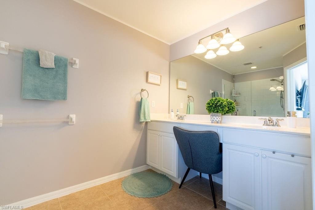 Full bath featuring double vanity, a shower stall, and light tile patterned floors