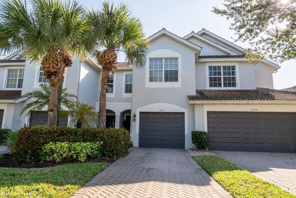View of front of home with decorative driveway, an attached garage, stucco siding, and a tile roof