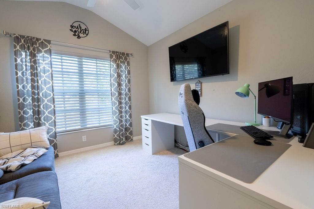 Office featuring lofted ceiling, light colored carpet, and ceiling fan