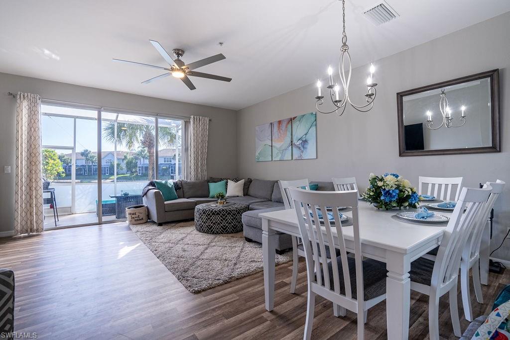 Dining room featuring wood finished floors, ceiling fan, and a chandelier