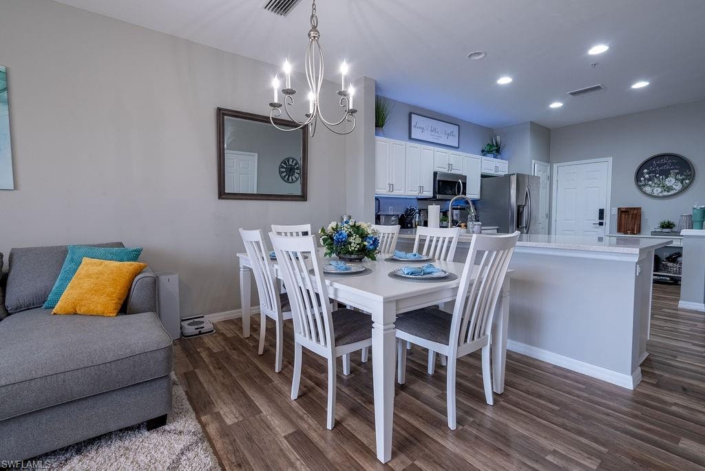 Dining room featuring dark wood-type flooring, recessed lighting, and a chandelier