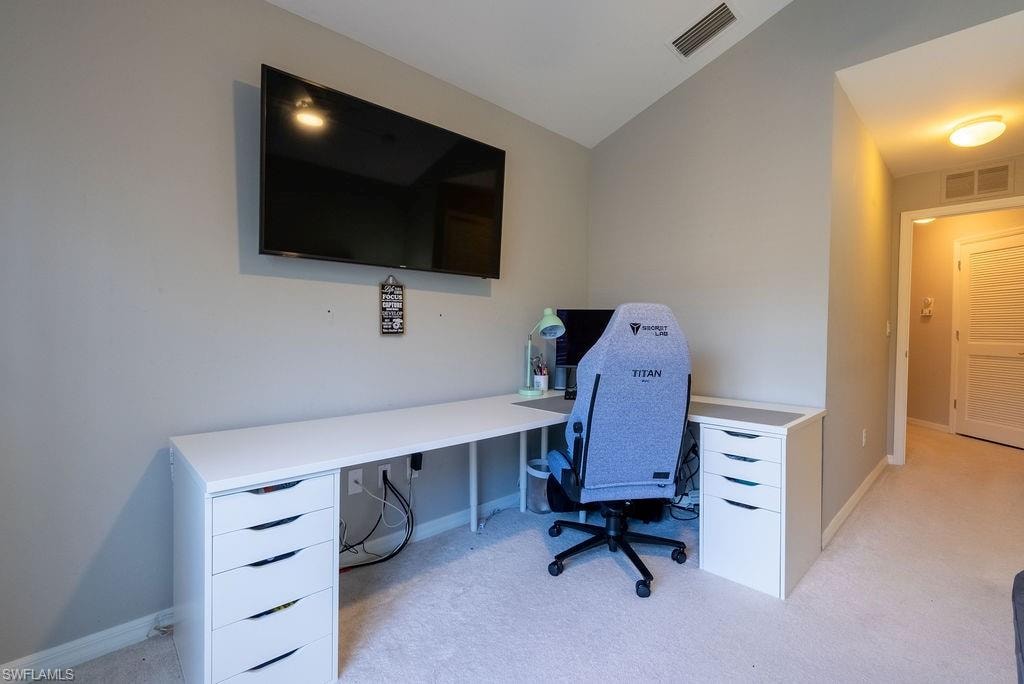 Home office featuring light carpet