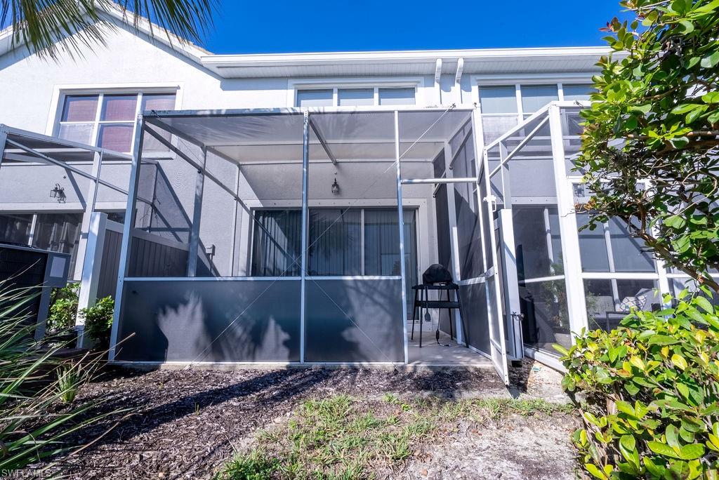 Rear view of property with a lanai, a sunroom, and stucco siding