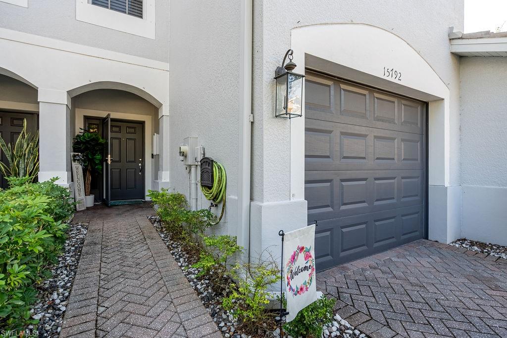 Entrance to property featuring a garage and stucco siding