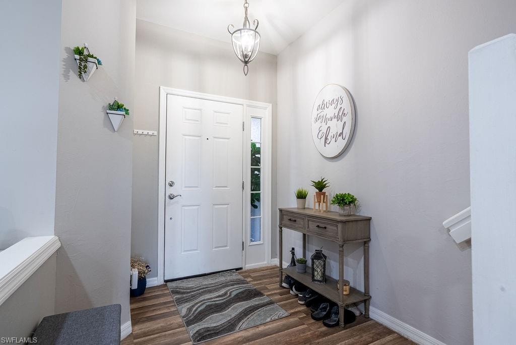Foyer with dark wood-style flooring and a chandelier