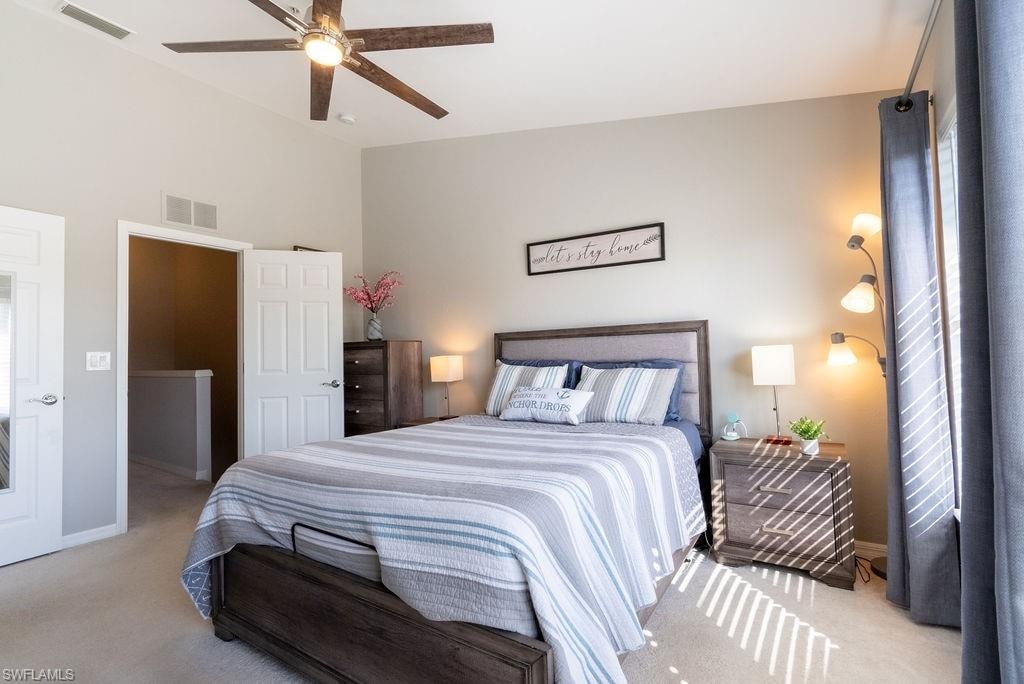 Carpeted bedroom with ceiling fan and baseboards