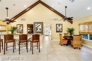 Vaulted ceiling with exposed wood beams, featuring recessed lighting and ceiling fans