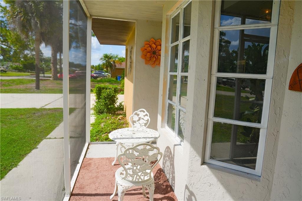 Screened front porch with textured exterior walls and grid-pattern windows