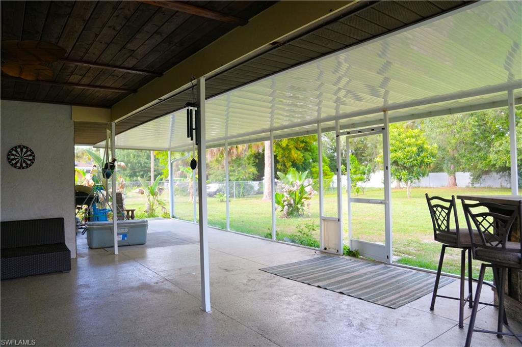 Spacious screened patio featuring a concrete floor, white frame enclosure, and a partial wood plank ceiling