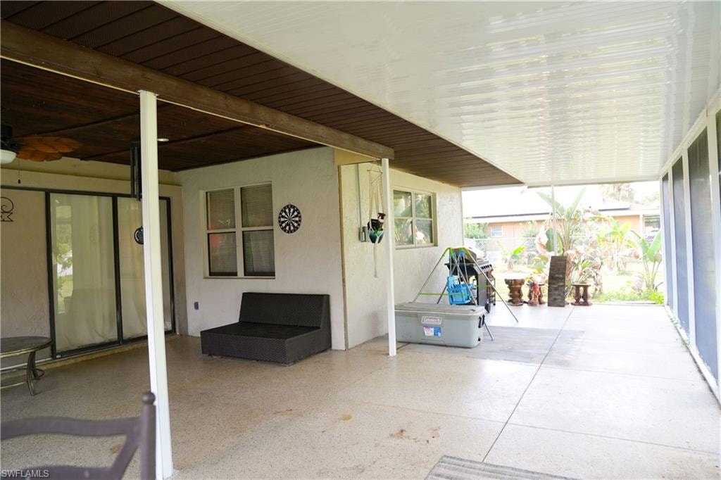 Covered patio featuring a durable concrete floor, an enclosed screened area, and sliding glass door access to the interior