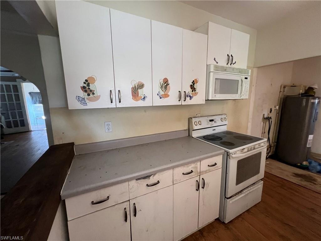 Kitchen area featuring white cabinetry, a built-in microwave, an electric range, and wood-finish flooring