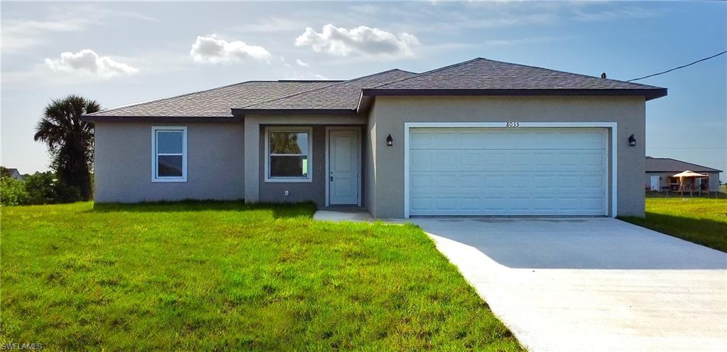 Single-story residence featuring a gray stucco exterior, dark shingle roof, and white-framed windows