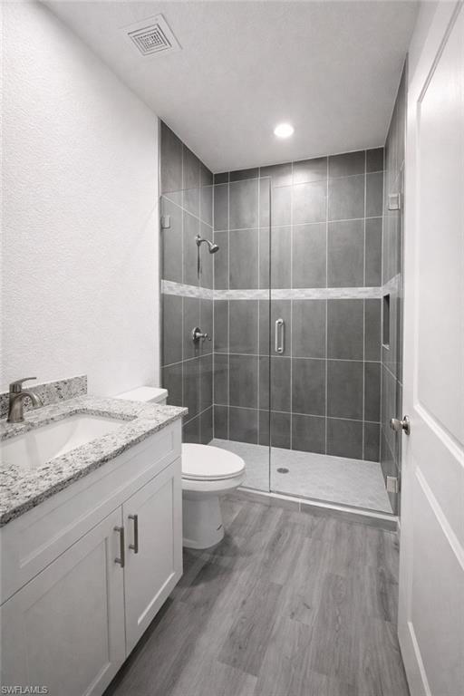 Contemporary bathroom featuring a glass-enclosed shower with gray tile, a decorative accent tile band, and a built-in shower niche